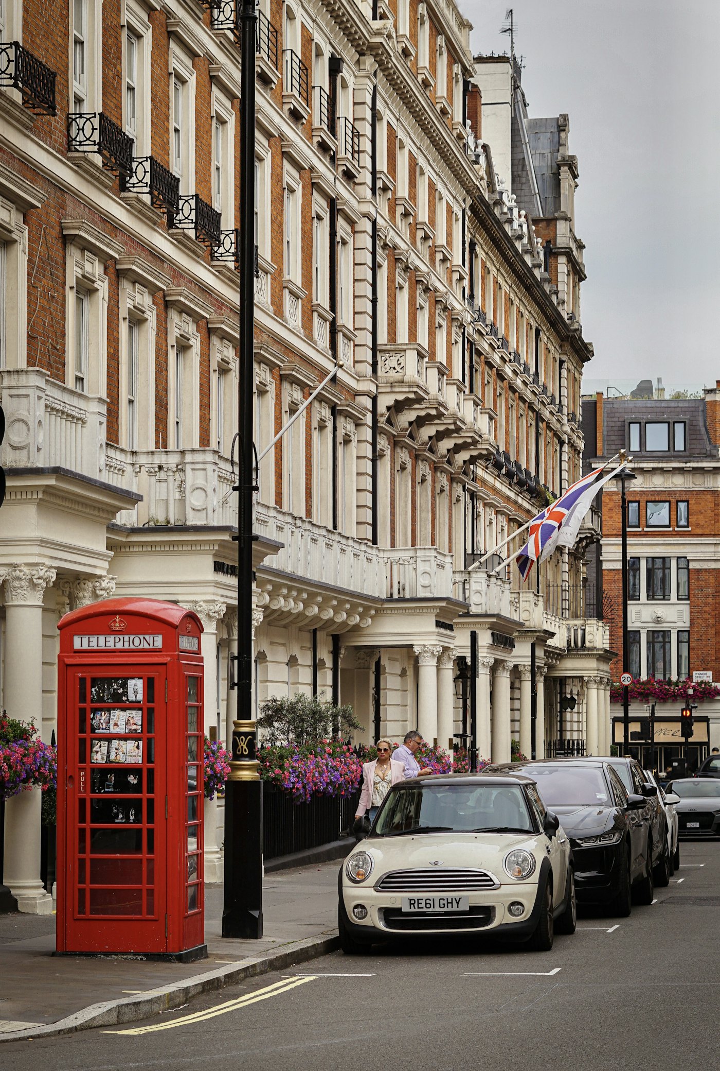 A central London street with period facades and a red telephone box